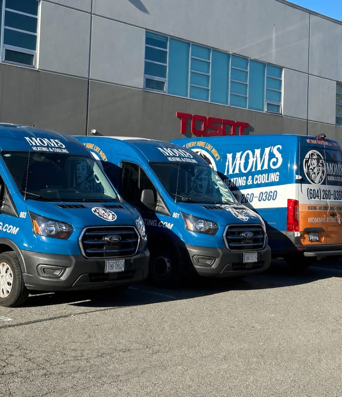 Three branded Mom's Heating & Cooling service vans